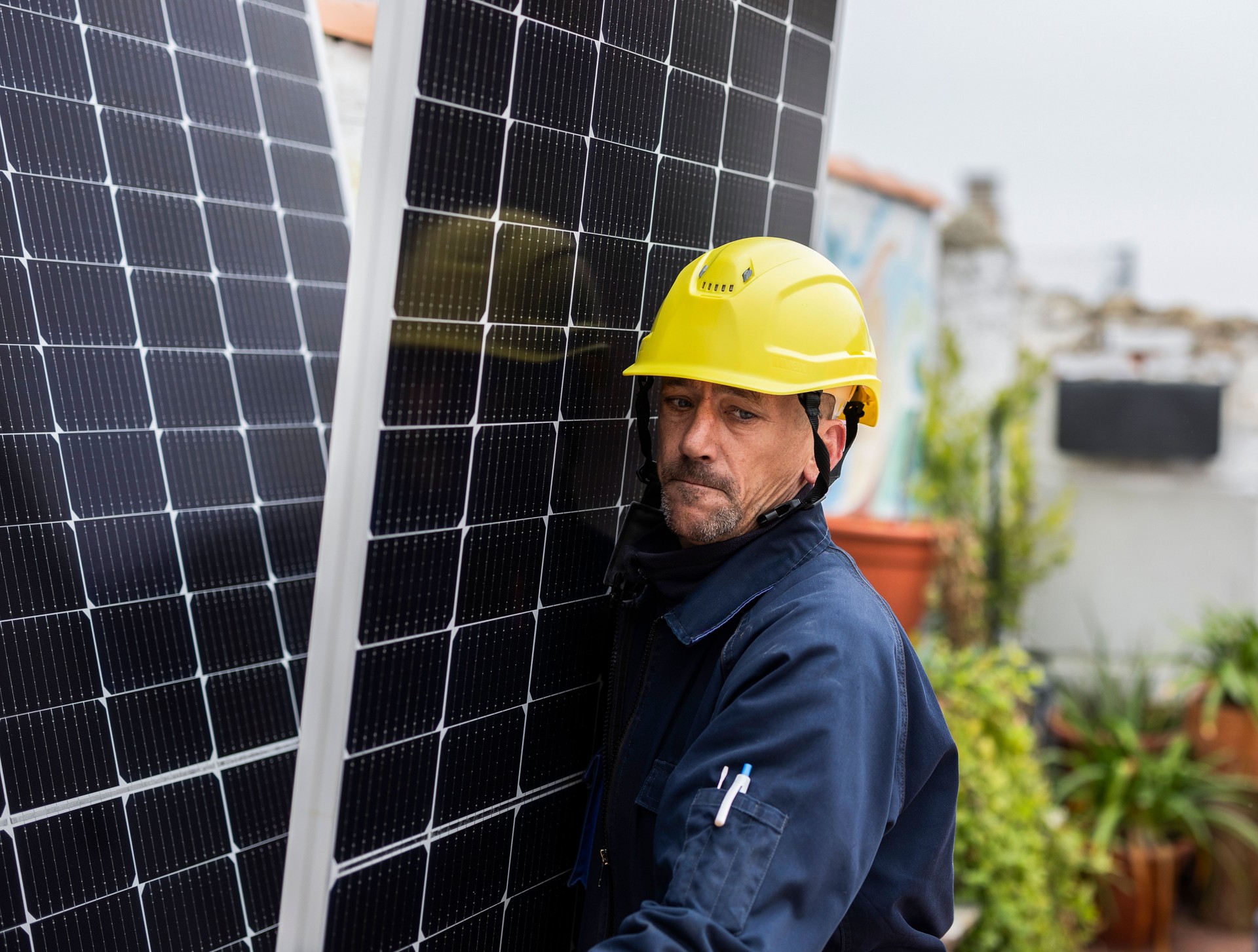 Technician installing solar panels on a rooftop for green energy production